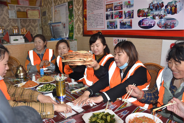 003：2022年4月28日，河南省濮阳市华龙区民族团结饭店，来自华龙区的“城市美容师”人正在分享“艾尼大叔”的新疆馕饼。.JPG
