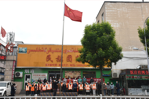 006：2022年4月28日，河南省濮阳市华龙区民族团结饭店“宴请环卫工”之前有个庄重的“升国旗”仪式，图为该饭店员工、升旗手艾依来提•阿不都艾尼正在升起鲜艳的五星红旗。.JPG